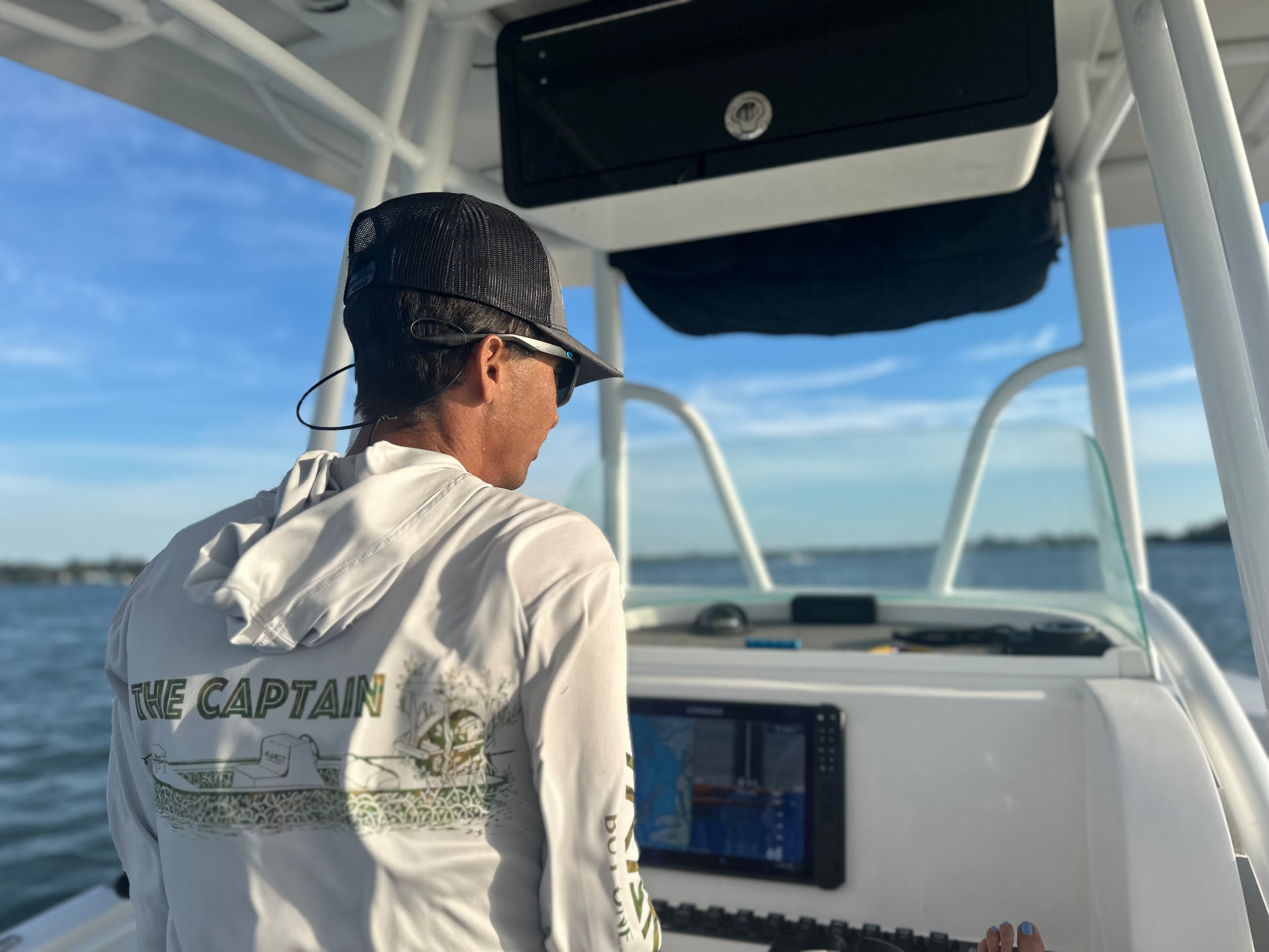 Captain Brendan running the boat from the helm on Sarasota Bay